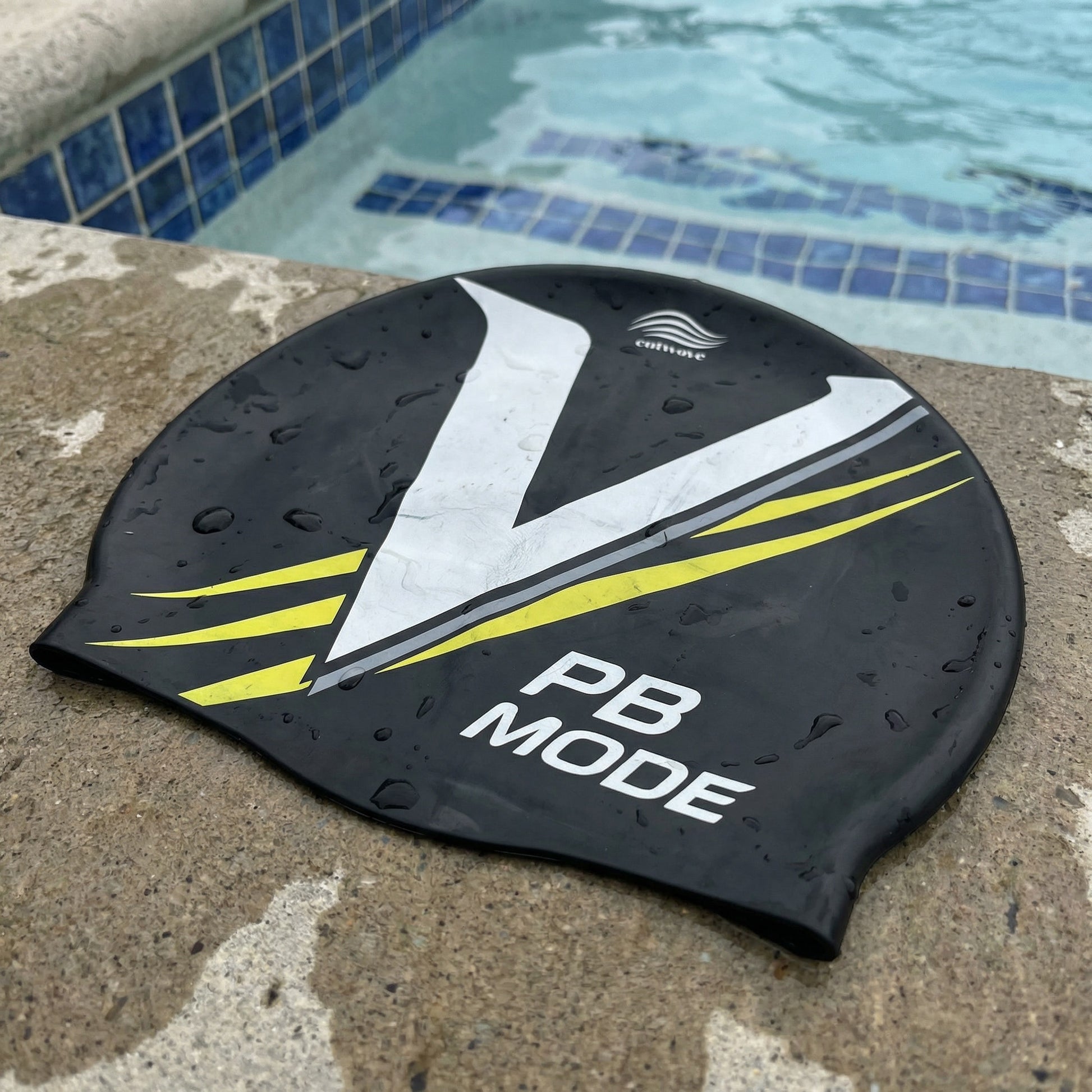 PB Mode V-design silicone swim cap by Cutwave - black with white and silver stripes on poolside