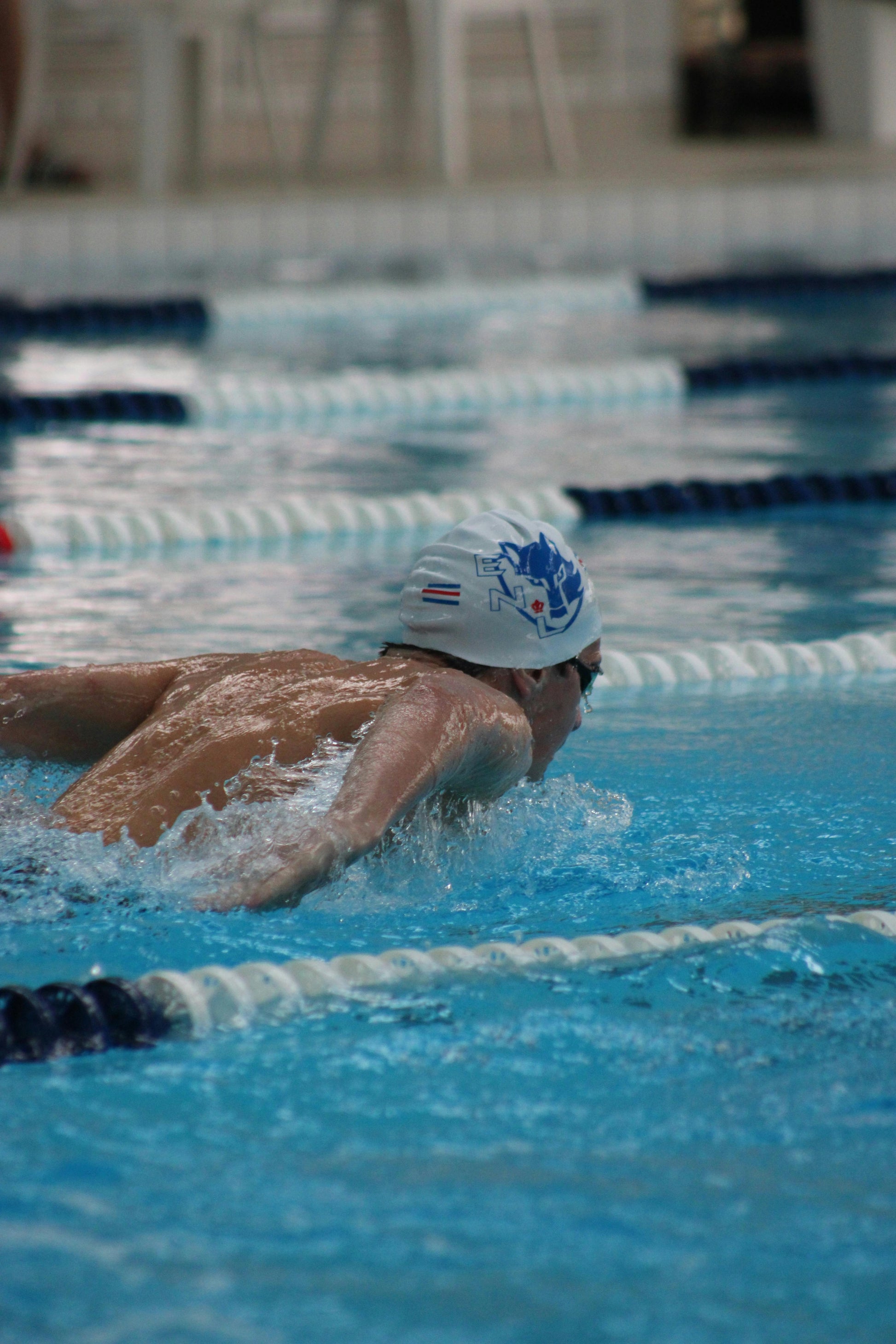 Swimmer in pool near CutWave swim cap product context